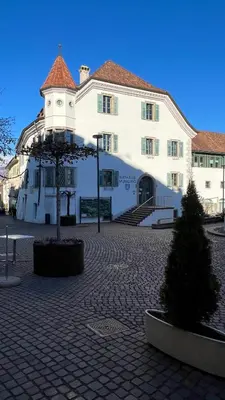 a large white building with a christmas tree in front of it at NEW Suite mar e monti in Appiano sulla Strada del Vino