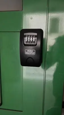 a black button on the side of a green locker at NEW Suite mar e monti in Appiano sulla Strada del Vino