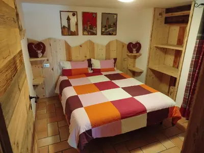 a bedroom with a bed in a room with wooden walls at Botton d'oro in Campitello di Fassa