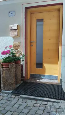 a wooden front door of a house with flowers at Botton d'oro in Campitello di Fassa