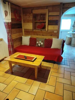 a living room with a red couch and a coffee table at Botton d'oro in Campitello di Fassa