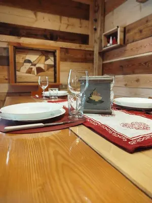 a wooden table with plates and glasses on it at Botton d'oro in Campitello di Fassa