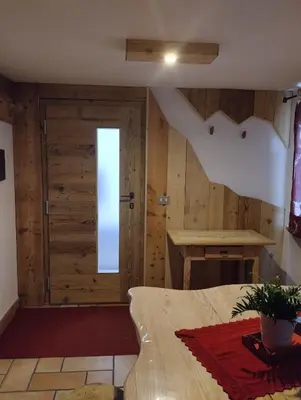a bedroom with wooden walls and a door at Botton d'oro in Campitello di Fassa