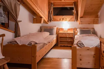 two beds in a room with wooden ceilings at SciliarGuestHouse-due piani parcheggio privato in Castelrotto