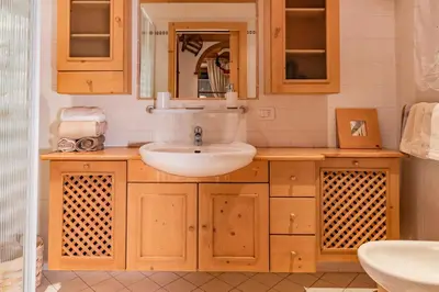 a bathroom with a sink and a mirror at SciliarGuestHouse-due piani parcheggio privato in Castelrotto