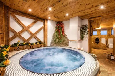 a hot tub in a room with a wooden ceiling at Romantic Charming Hotel Rancolin in Moena