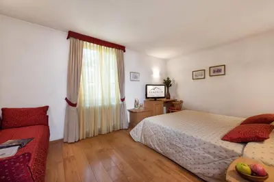 a bedroom with a bed and a window at Romantic Charming Hotel Rancolin in Moena