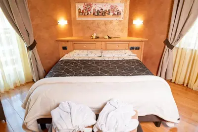 a bedroom with a bed with two towels on it at Romantic Charming Hotel Rancolin in Moena