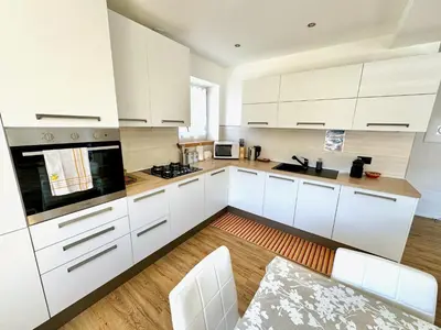 a kitchen with white cabinets and white appliances at Villa Dada in Predazzo