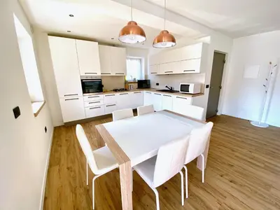 a kitchen with a white table and white chairs at Villa Dada in Predazzo