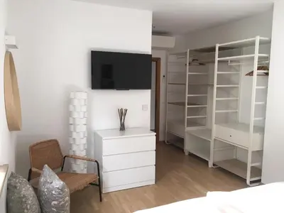 a bedroom with a white closet with a tv on the wall at LaSiesta Merano in Merano