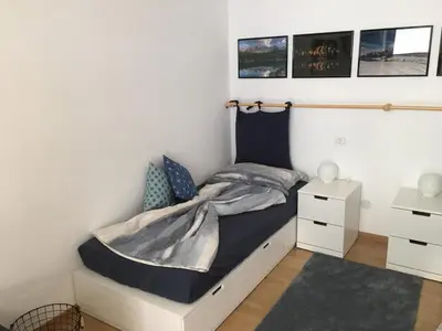 a small bedroom with a bed and a nightstand at LaSiesta Merano in Merano