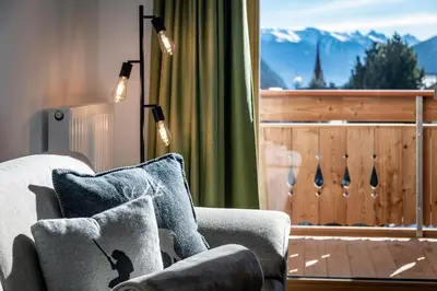 a living room with a couch and a balcony at Mesnerhof in Valles