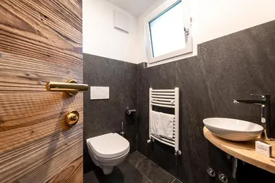 a bathroom with a toilet and a sink at Hotel Majon Miramonti in Canazei