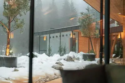 a house with snow on the ground in front of it at Hotel Majon Miramonti in Canazei