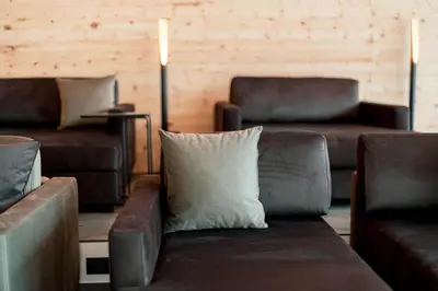 a living room with leather couches and a pillow at Hotel Majon Miramonti in Canazei