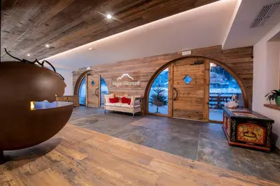 a large room with wooden walls and a living room at Hotel Majon Miramonti in Canazei