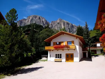 a building with a balcony with mountains in the background at La Pineta in Colfosco