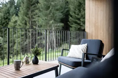 a table and a chair on a porch with a table and a chair at Stelza Nature Chalet in Val di Vizze
