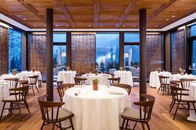 a hotel room with a bed and a chair at Faloria Mountain Spa Resort in Cortina dʼAmpezzo