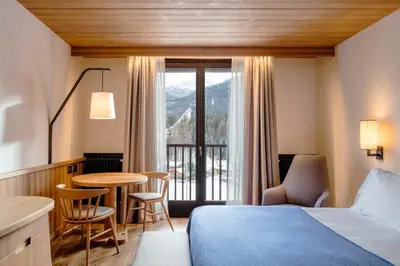 a bathroom with a tub and a shower with green tiles at Faloria Mountain Spa Resort in Cortina dʼAmpezzo