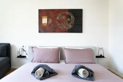 a bedroom with a bed with two towels on it at Dolomiti 65 mq new flat in the center of Bolzano in Bolzano