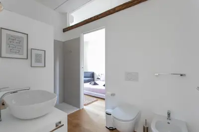 a white bathroom with a sink and a toilet at Dolomiti 65 mq new flat in the center of Bolzano in Bolzano