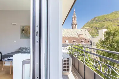 a balcony with a view of a church at Dolomiti 65 mq new flat in the center of Bolzano in Bolzano