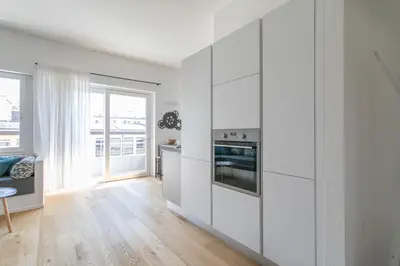 a white kitchen with white cabinets and a window at Dolomiti 65 mq new flat in the center of Bolzano in Bolzano