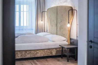 a bedroom with a bed with a large headboard at B&B Zur Traube in Vipiteno