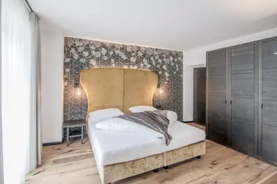 a bedroom with a bed with a headboard at B&B Zur Traube in Vipiteno