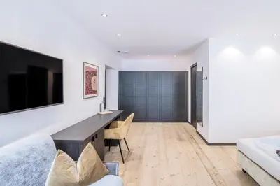 a living room with a desk and a tv at B&B Zur Traube in Vipiteno