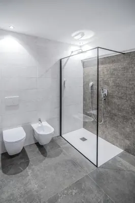 a bathroom with a shower and a toilet and a sink at B&B Zur Traube in Vipiteno