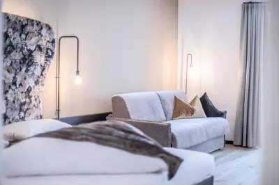 a living room with a couch and a chair at B&B Zur Traube in Vipiteno