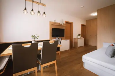 a kitchen and living room with a table and a couch at dolomites view apartment in Rasun di Sopra