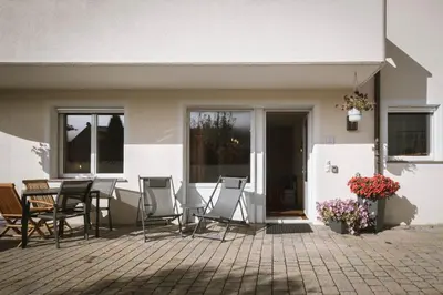a patio with chairs and a table in front of a house at dolomites view apartment in Rasun di Sopra