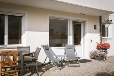a patio with a table and chairs on a patio at dolomites view apartment in Rasun di Sopra