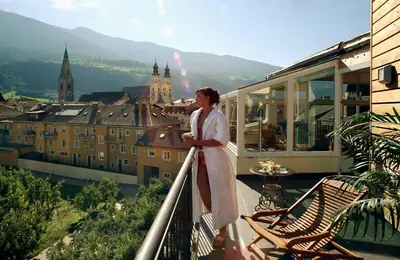 a woman standing on a balcony looking at a city at KRONE eat drink stay in Bressanone