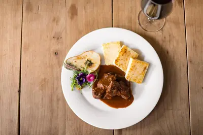 a plate of food with meat and bread on a table at KRONE eat drink stay in Bressanone