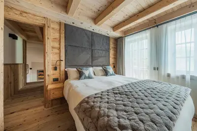 a bedroom with a large bed and wooden walls at Chalet Socrepes - Dolomiti Skyline in Cortina dʼAmpezzo