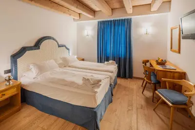 a hotel room with a bed and a desk and a desk at Royal Hotel Cortina in Cortina dʼAmpezzo