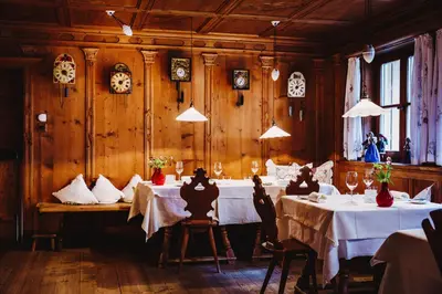 a dining room with two tables and clocks on the wall at Gourmet - Boutique Hotel Tanzer in Falzes