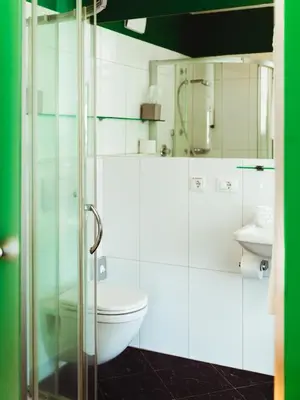 a white bathroom with a toilet and a sink at Gourmet - Boutique Hotel Tanzer in Falzes