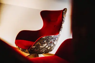a red chair sitting next to a red couch at Gourmet - Boutique Hotel Tanzer in Falzes