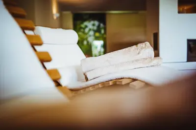 a stack of towels sitting on a counter in a bathroom at Gourmet - Boutique Hotel Tanzer in Falzes