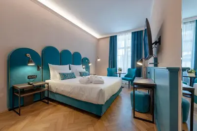 a bedroom with a bed with a blue headboard at Stadt Hotel Città in Bolzano