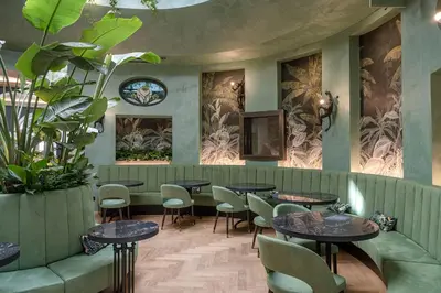 a restaurant with tables and chairs and plants at Stadt Hotel Città in Bolzano