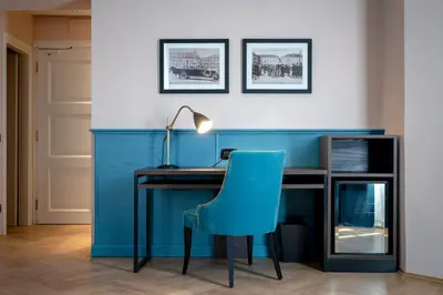 a blue desk with a blue chair and a lamp at Stadt Hotel Città in Bolzano