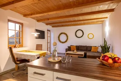 a living room with a couch and a table at Unterkofler Farm Holiday - Peaceful Nature Stay with Stunning Panoramic Views near Bolzano in San Genesio Atesino