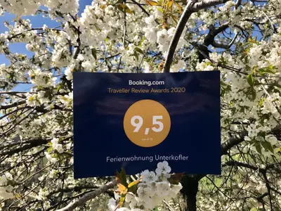 a sign hanging from a tree with white flowers at Unterkofler Farm Holiday - Peaceful Nature Stay with Stunning Panoramic Views near Bolzano in San Genesio Atesino